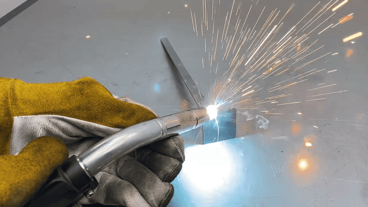 lassen van een metalen onderdeel mig mag las Een metalen onderdeel wordt professioneel gelast met het MIG/MAG-lasproces, waarbij vonken vrijkomen tijdens het smelten van het metaal.