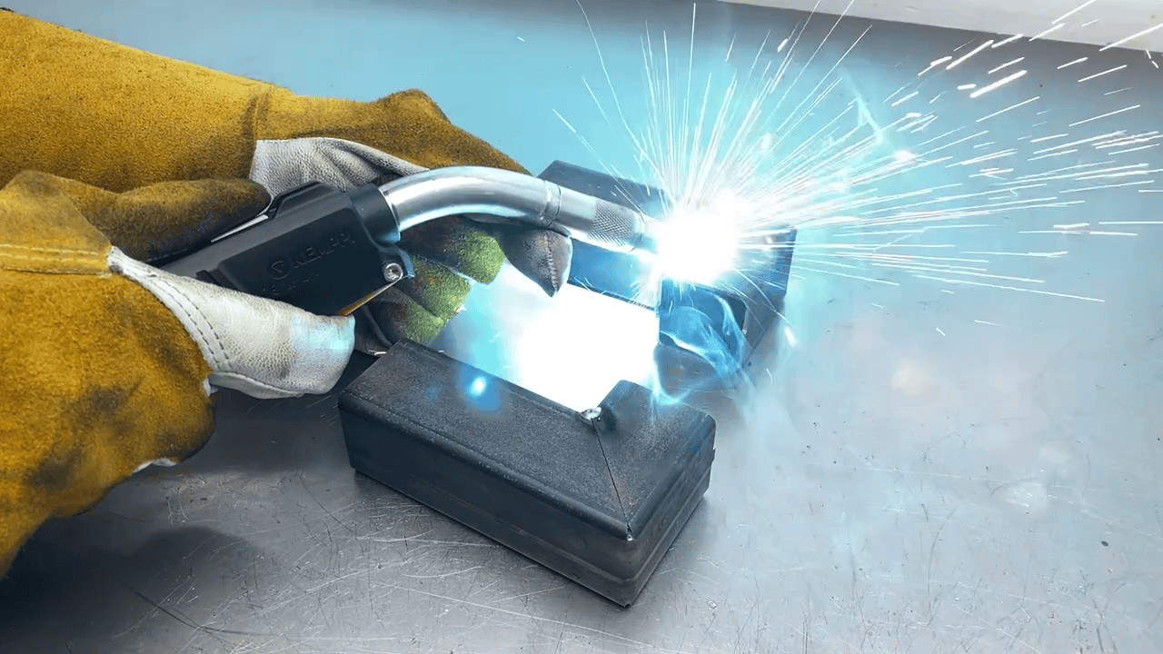 zelf lassen van kokerstaal met mag lasapparaat Zelf kokerstaal lassen met een MAG-lasapparaat – een stevige hoekverbinding wordt gelast op een werkbank, met vonken en smeltbad zichtbaar.